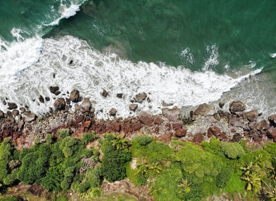 有绿色苔藓和棕色岩石的棕色岩石海岸